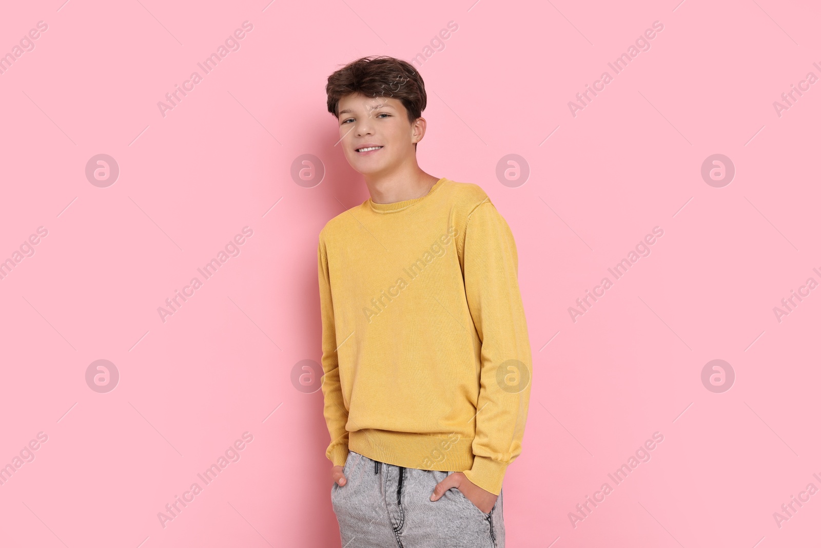 Photo of Portrait of happy teenage boy on pink background