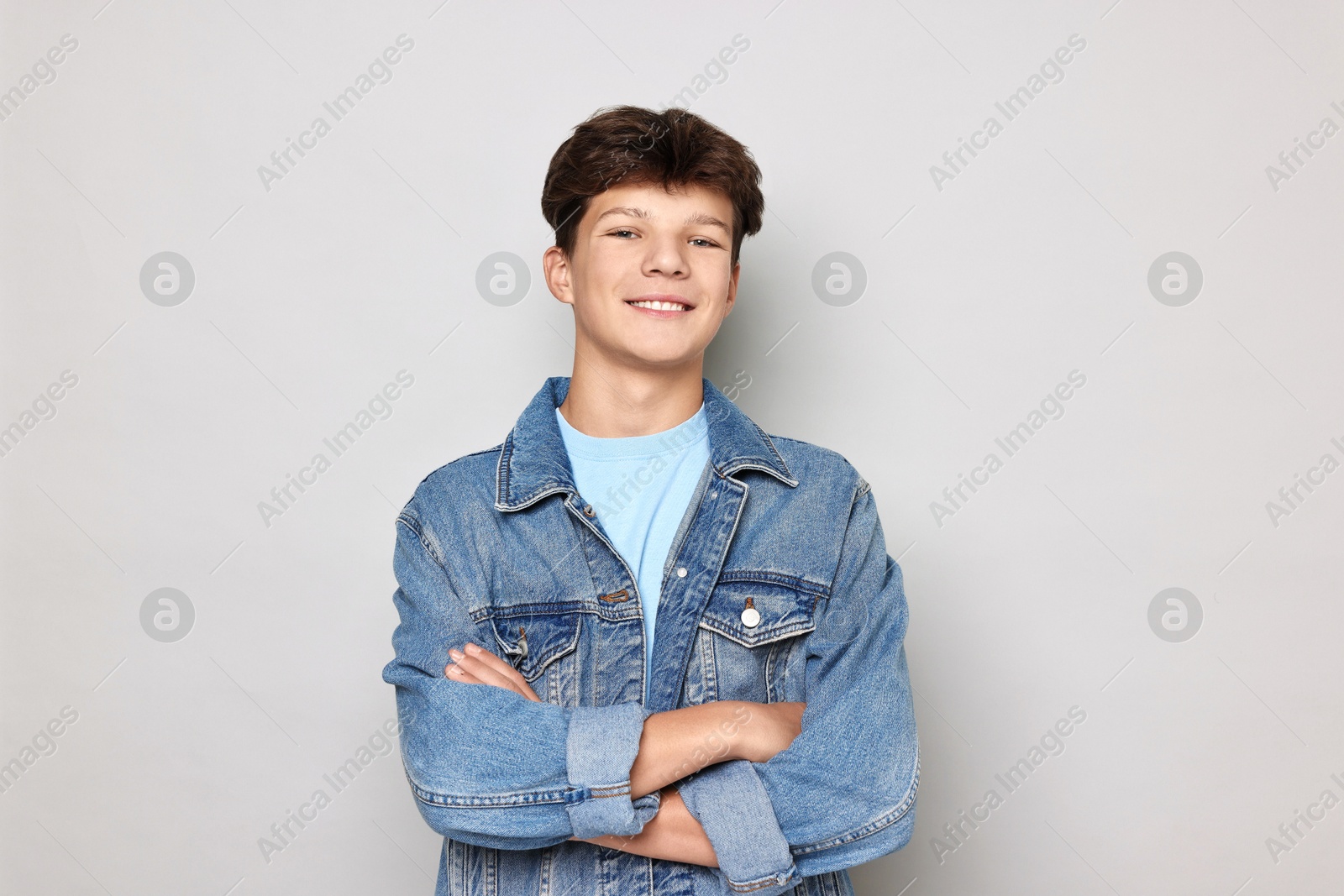 Photo of Portrait of happy teenage boy on light grey background