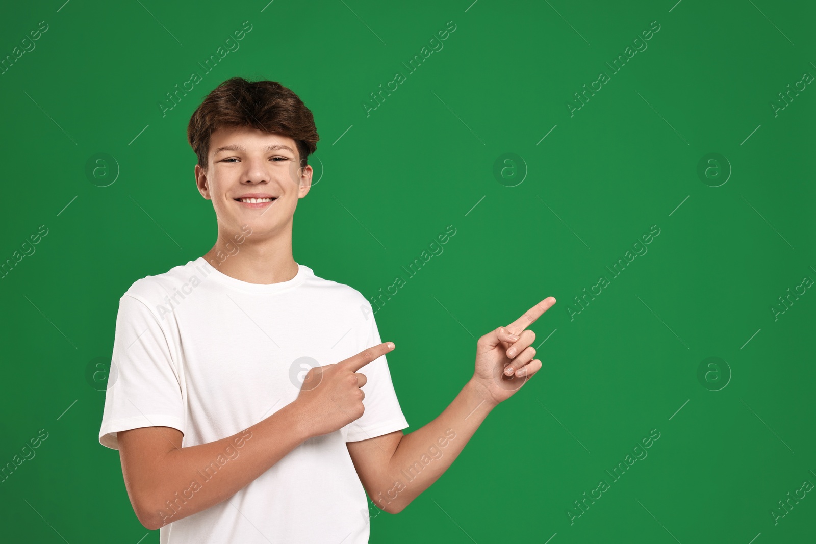 Photo of Portrait of teenage boy on green background, space for text