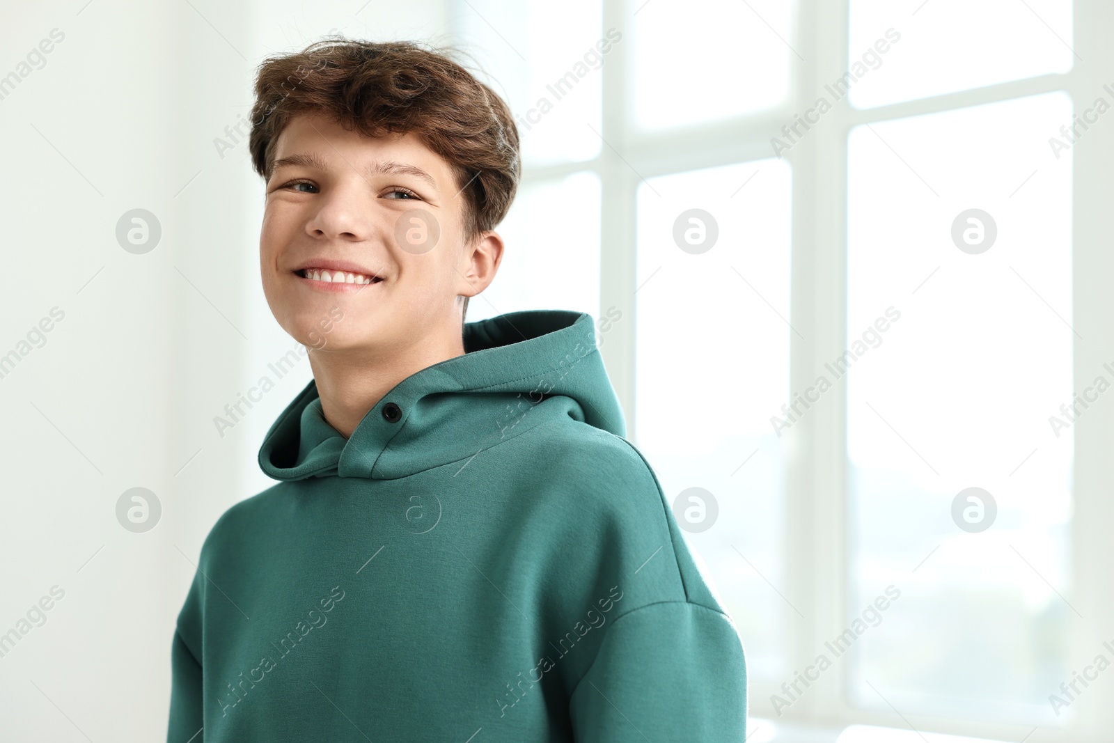 Photo of Portrait of happy teenage boy indoors, space for text