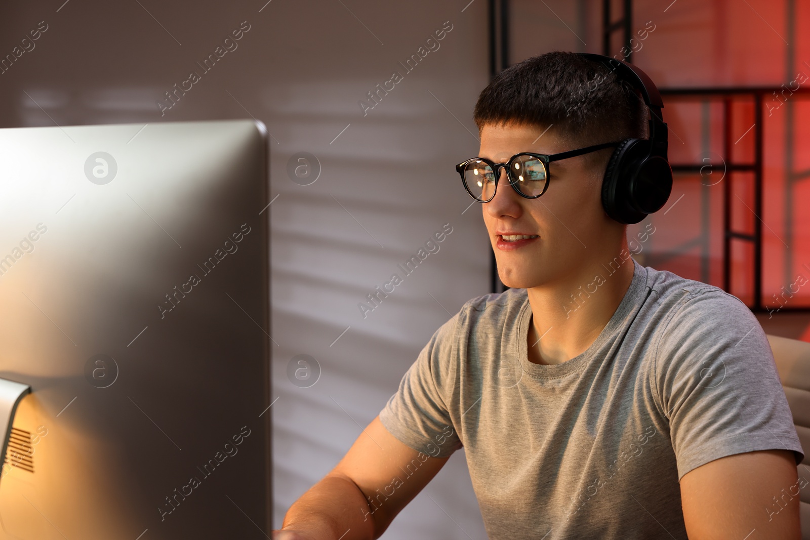 Photo of Young man playing video game at table indoors