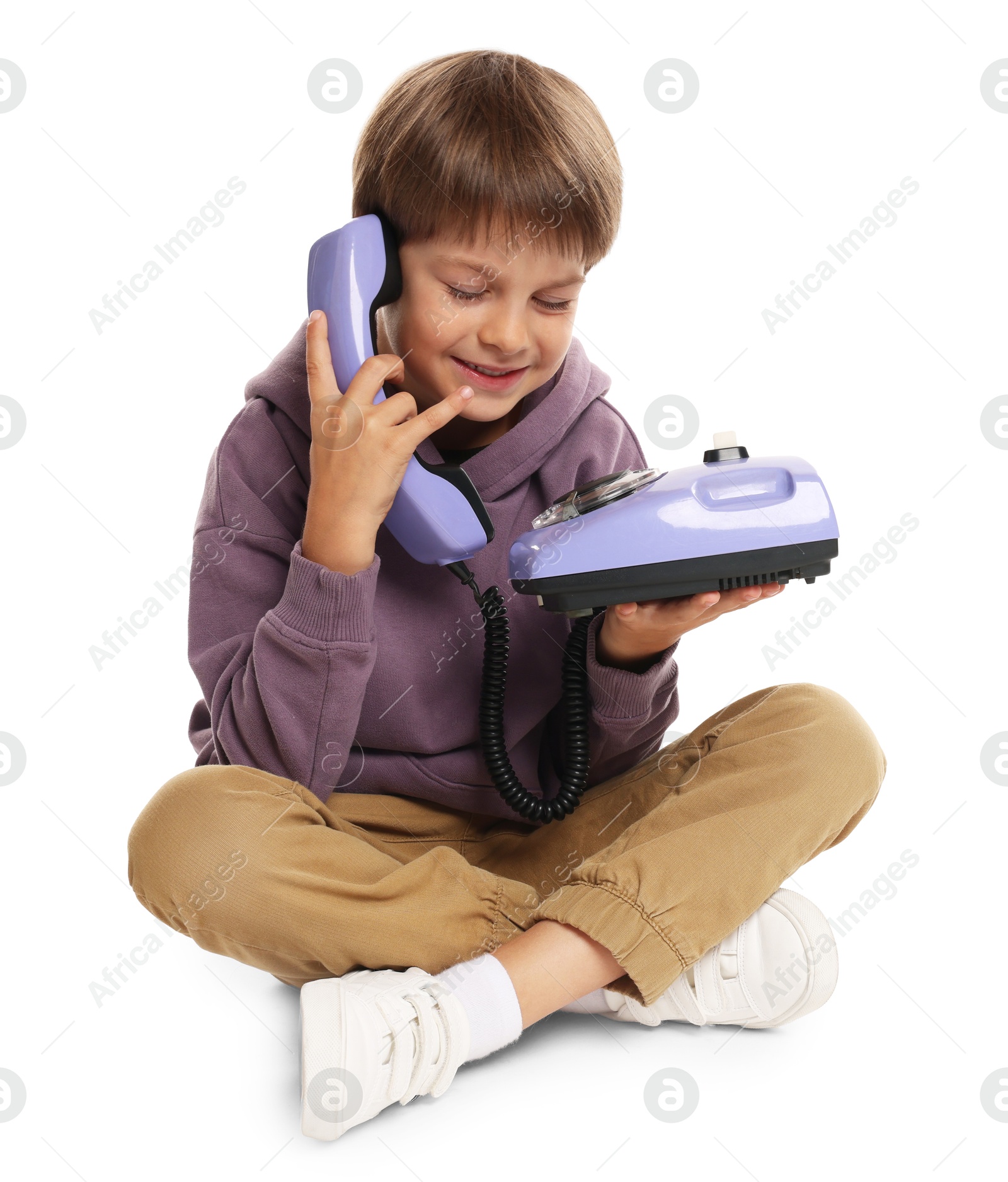 Photo of Cute little boy with old telephone on white background