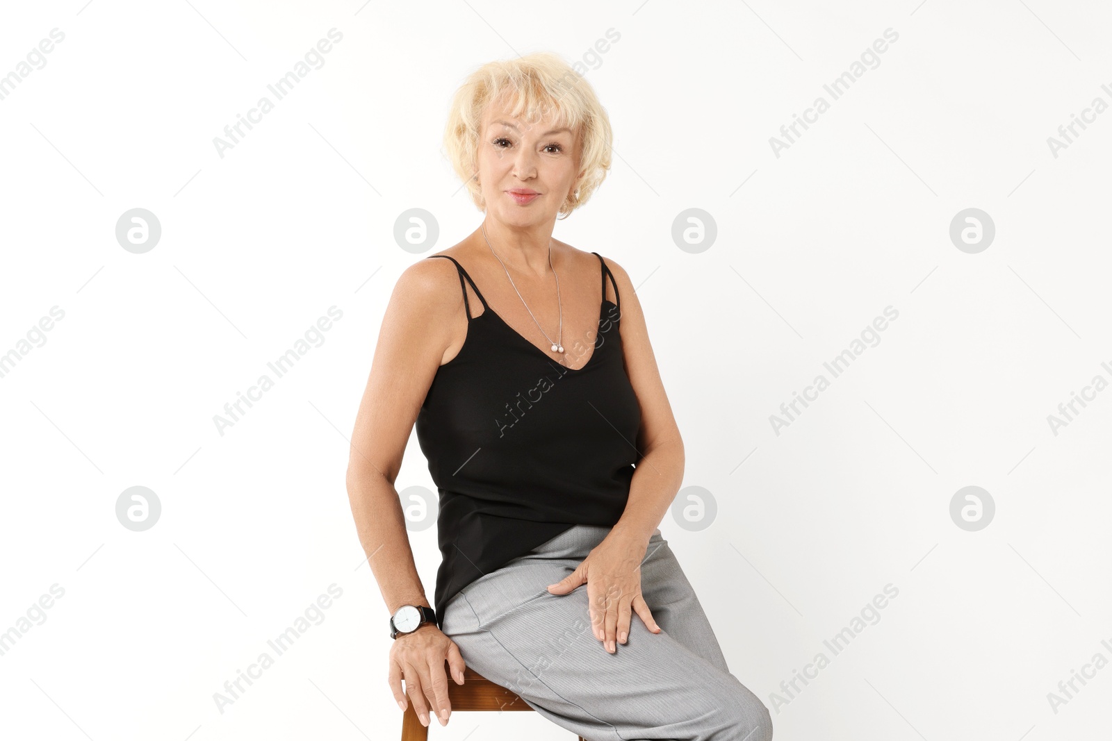 Photo of Beautiful senior woman sitting on chair against white background