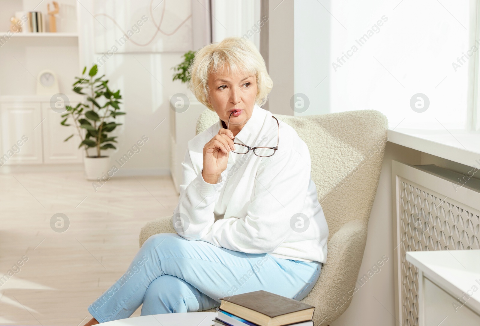 Photo of Beautiful senior woman sitting on armchair at home