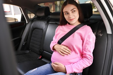 Photo of Pregnant woman with safety belt in car