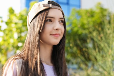 Photo of Portrait of teenage girl in stylish cap outdoors. Space for text