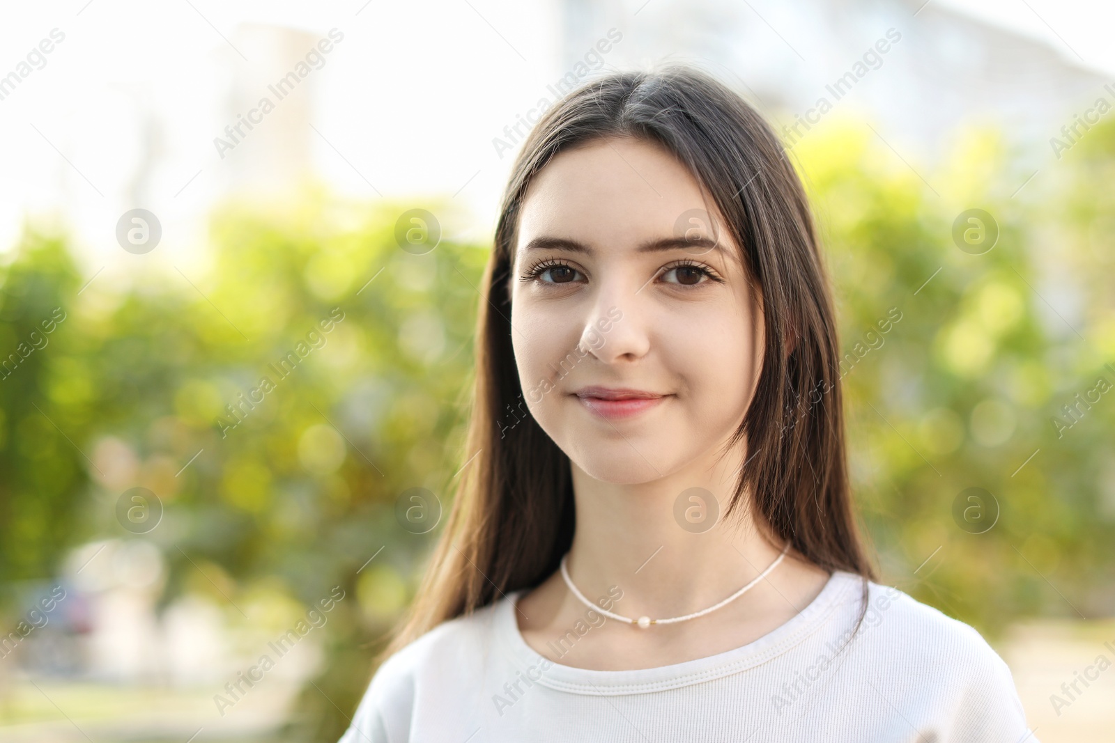 Photo of Portrait of beautiful teenage girl on city street. Space for text