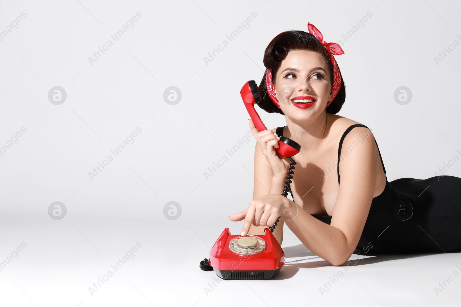 Photo of Pin-up woman with telephone on light background, space for text