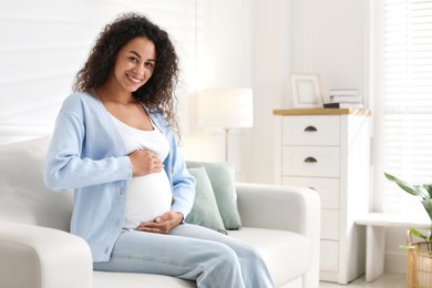 Photo of Portrait of beautiful pregnant woman on sofa at home