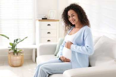 Photo of Portrait of beautiful pregnant woman on sofa at home