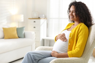 Photo of Portrait of beautiful pregnant woman in armchair at home