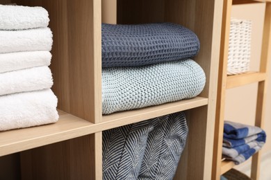 Different home textile on shelving units indoors, closeup