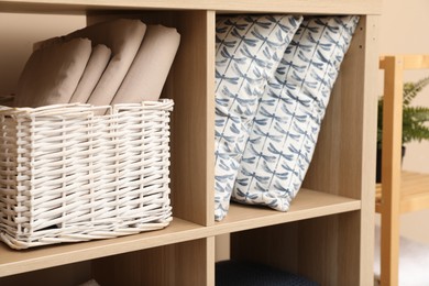 Photo of Different home textile on shelving unit indoors, closeup