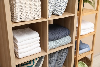 Different home textile on shelving units indoors, closeup