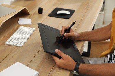 Photo of Professional retoucher working on graphic tablet at desk, closeup