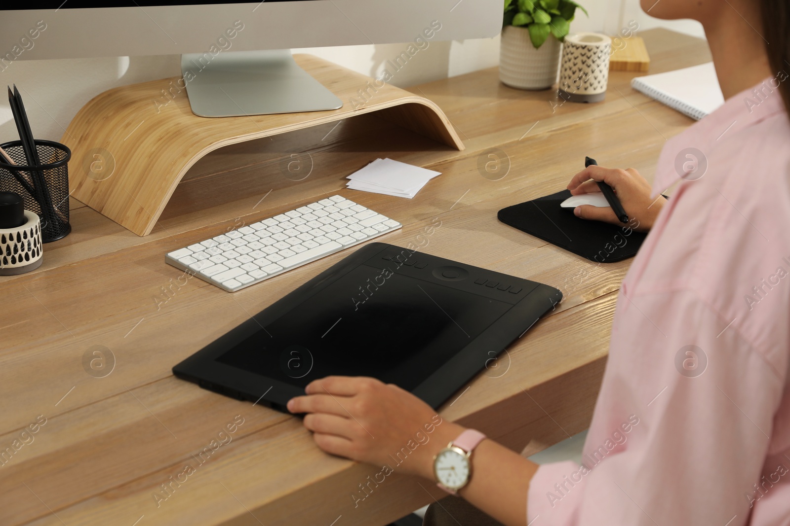 Photo of Professional retoucher working on graphic tablet at desk, closeup