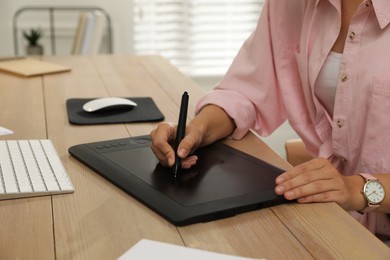 Photo of Professional retoucher working on graphic tablet at desk, closeup