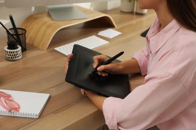 Photo of Professional retoucher working on graphic tablet at desk, closeup