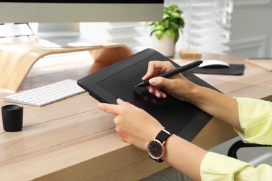 Photo of Professional retoucher working on graphic tablet at desk, closeup