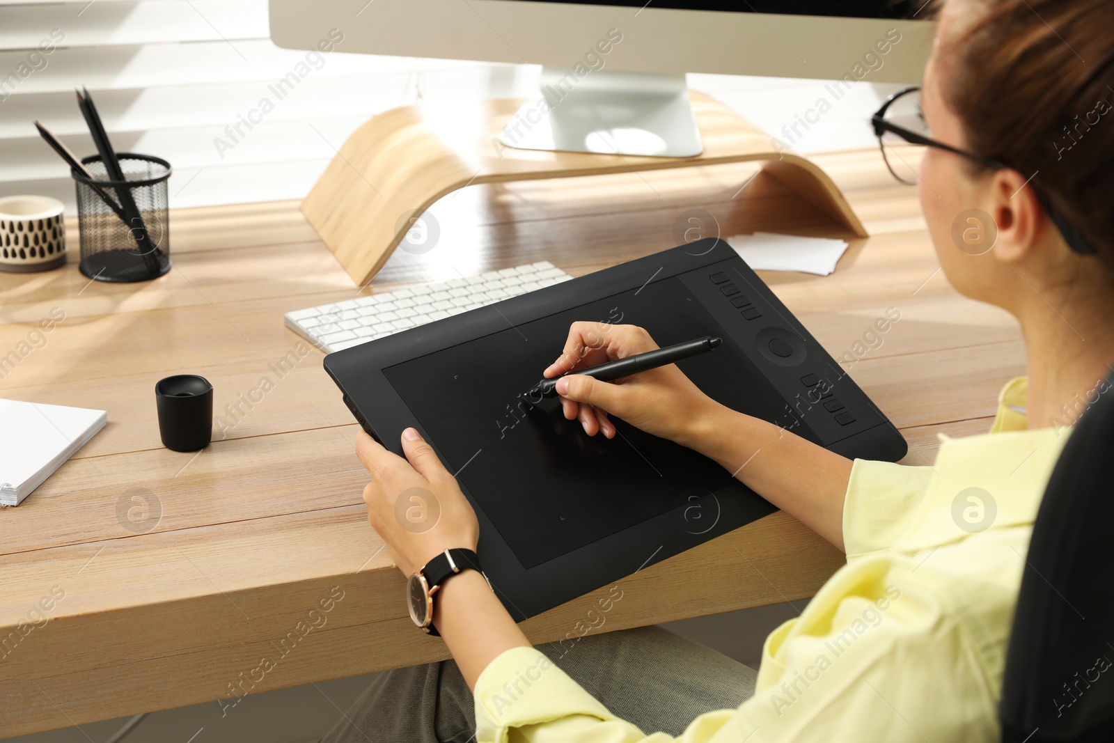 Photo of Professional retoucher working on graphic tablet at desk, closeup