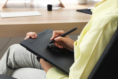 Photo of Professional retoucher working on graphic tablet, closeup