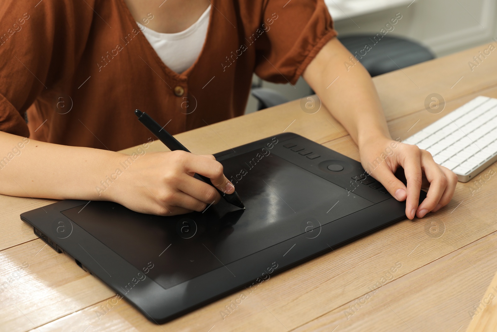 Photo of Professional retoucher working on graphic tablet at desk, closeup