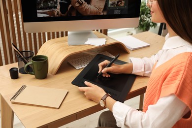 Photo of Professional retoucher working on graphic tablet at desk, closeup