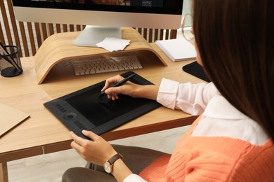 Photo of Professional retoucher working on graphic tablet at desk, closeup