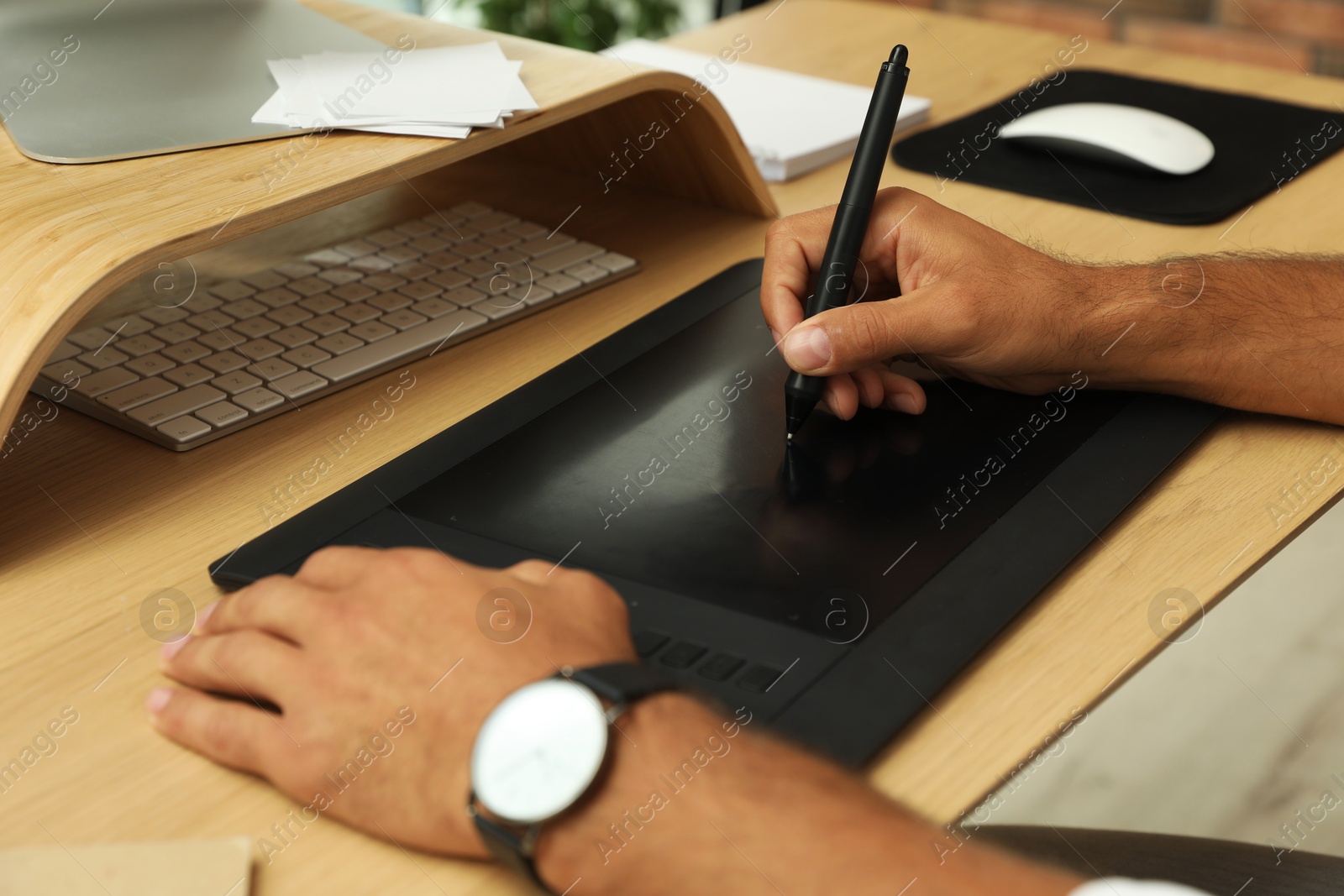 Photo of Professional retoucher working on graphic tablet at desk, closeup