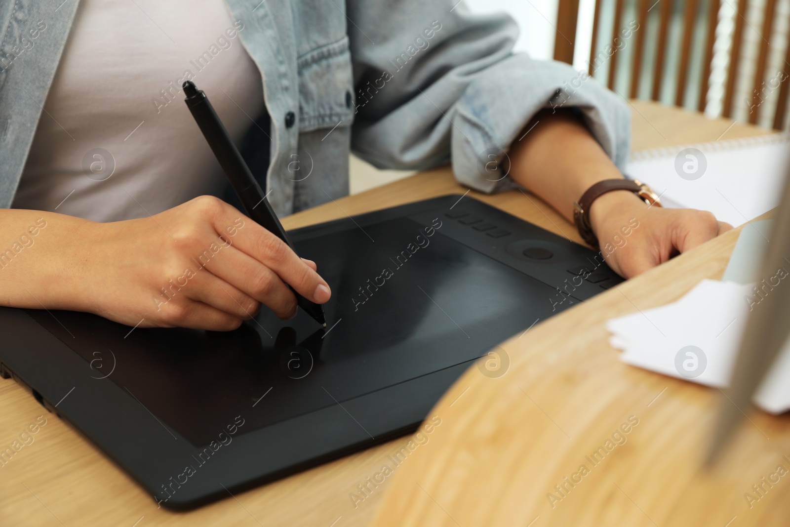 Photo of Professional retoucher working on graphic tablet at desk, closeup