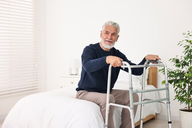 Photo of Senior man with walking frame on bed in hospital ward