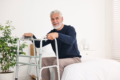 Photo of Senior man with walking frame on bed in hospital ward