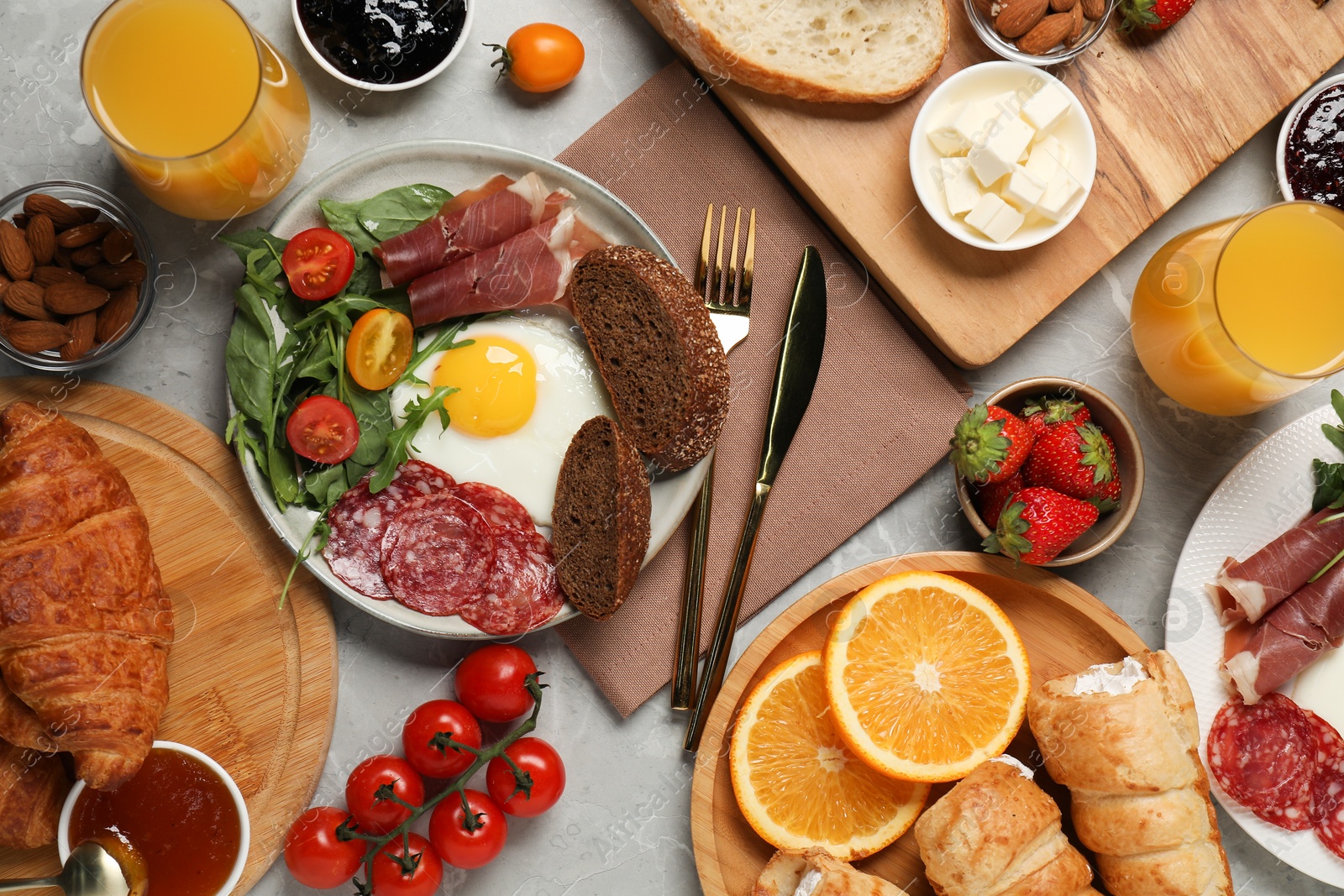 Photo of Different tasty food served for brunch on grey marble table, flat lay