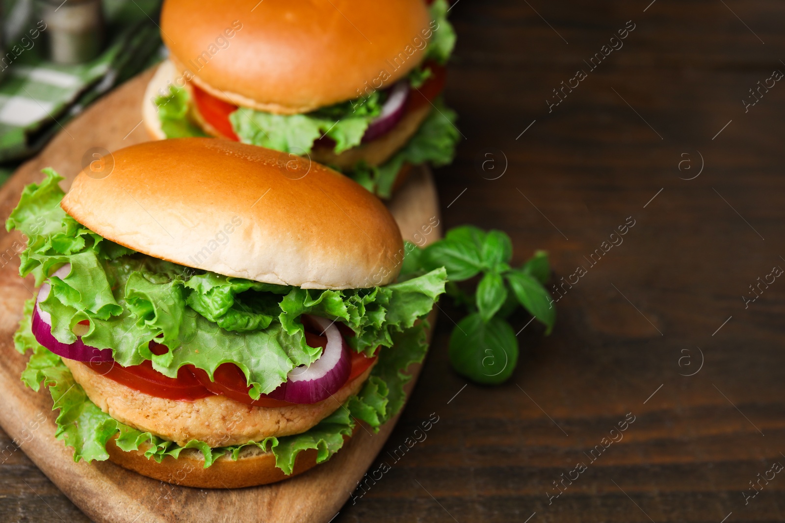 Photo of Delicious vegetarian burgers with chickpea cutlets on wooden table, closeup. Space for text