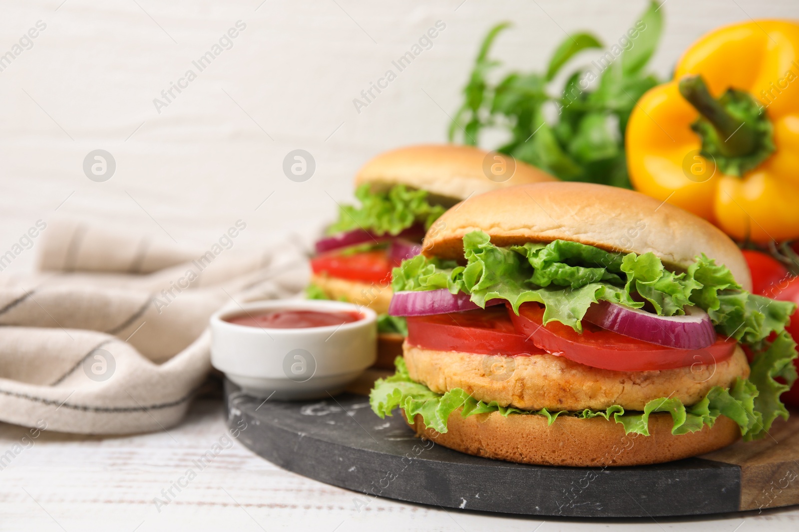 Photo of Delicious vegetarian burgers with chickpea cutlets and sauce on white wooden table, closeup