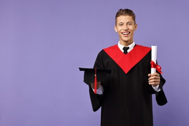 Photo of Happy student with diploma after graduation on violet background. Space for text