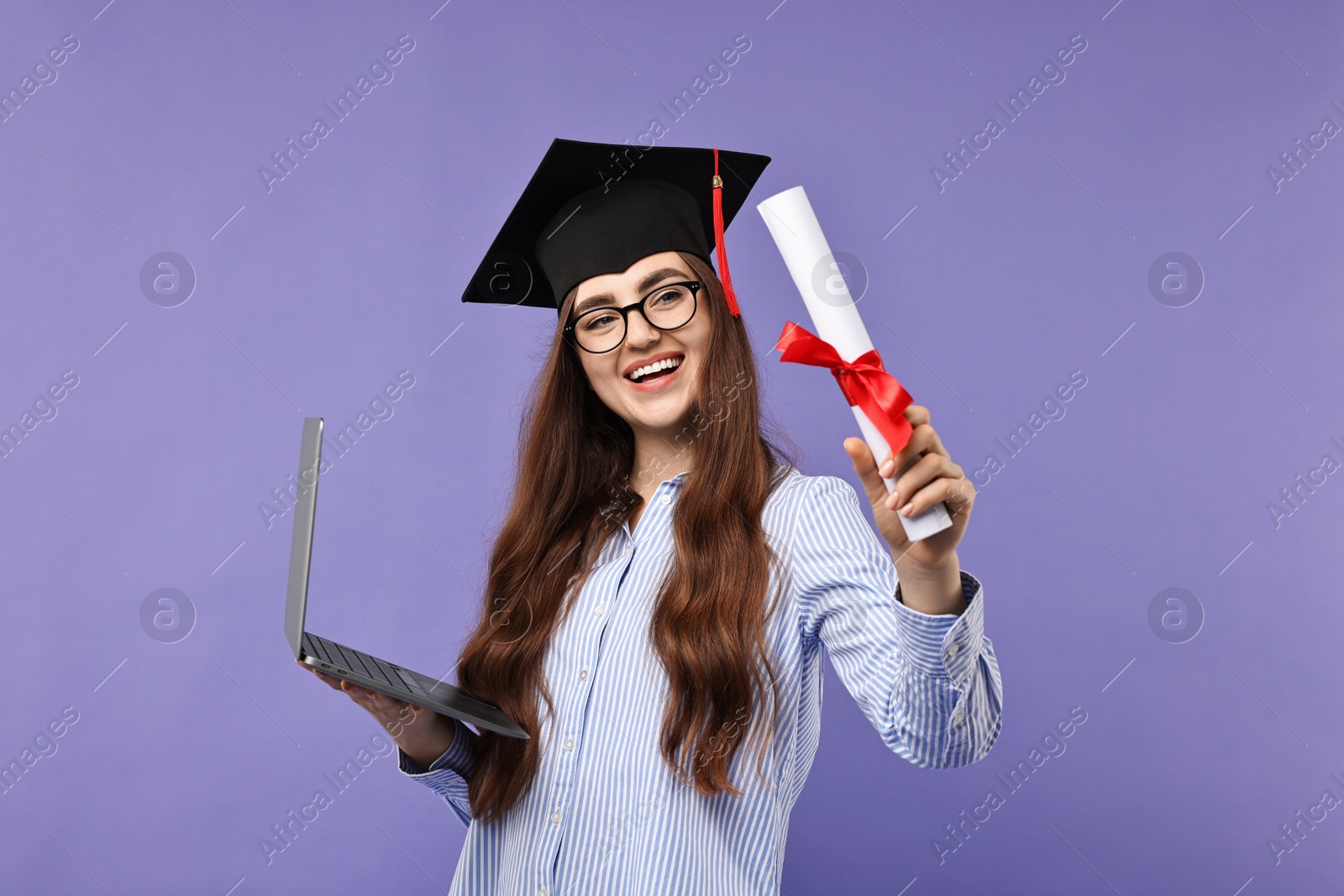 Photo of Happy student with laptop and diploma after graduation on violet background