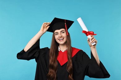 Photo of Happy student with diploma after graduation on light blue background