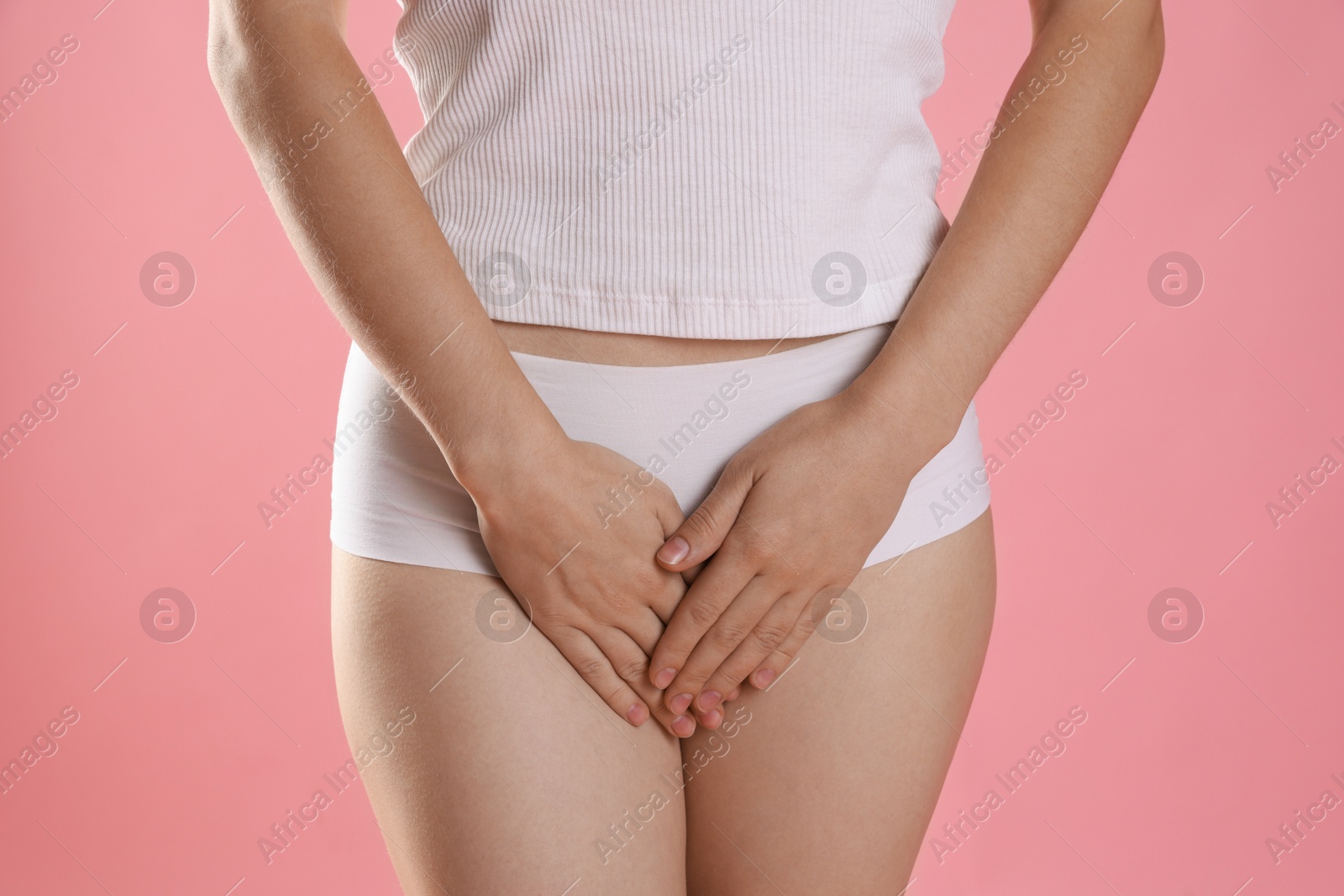 Photo of STD (sexually transmitted disease). Woman suffering from symptoms on pink background, closeup