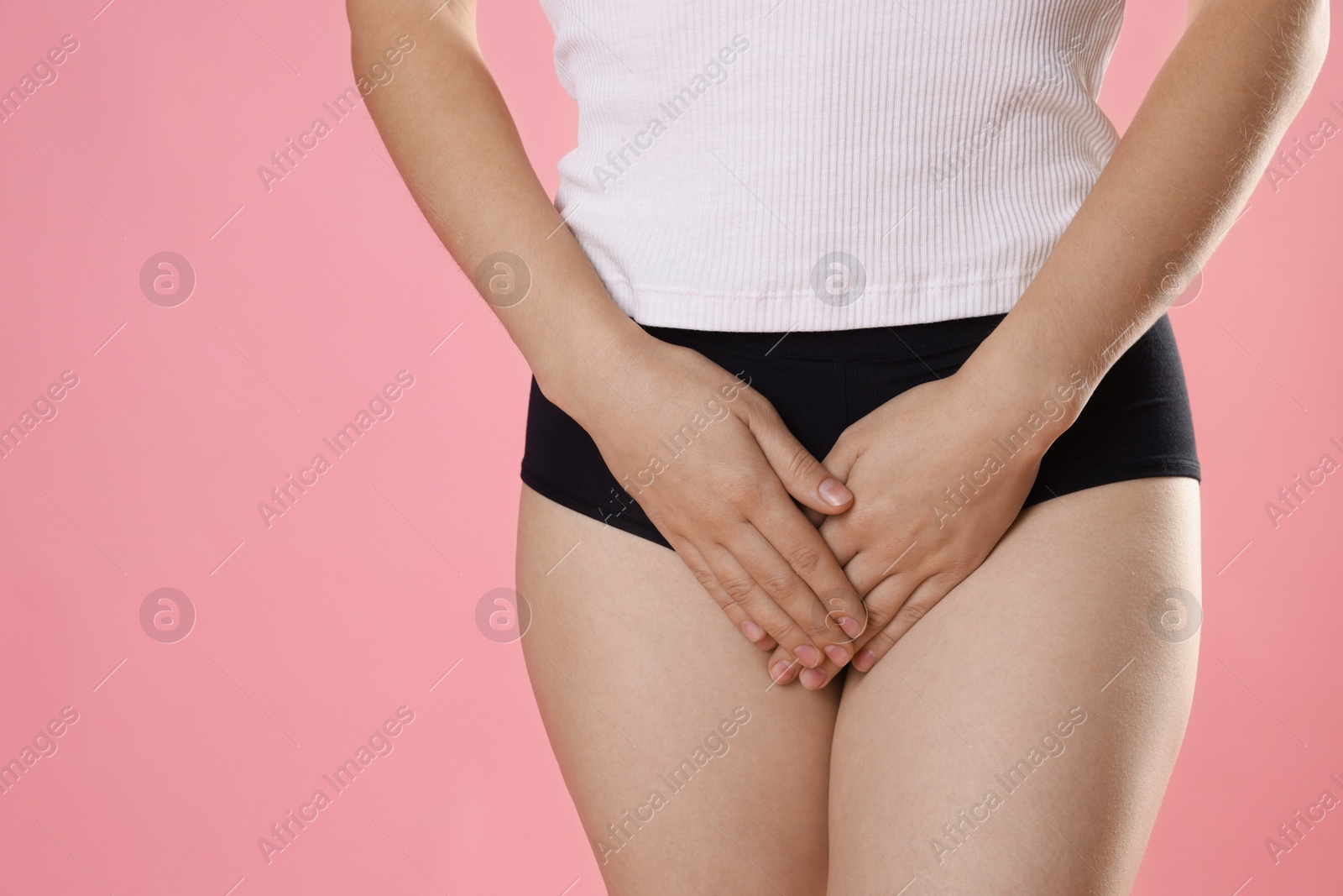 Photo of STD (sexually transmitted disease). Woman suffering from symptoms on pink background, closeup. Space for text