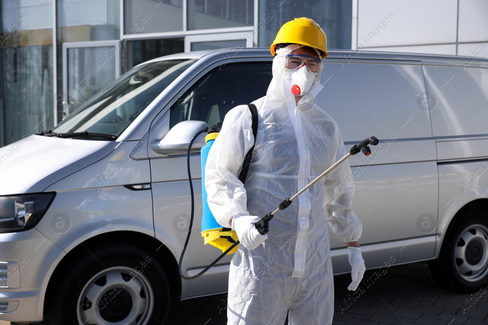 Photo of Pest control worker with spray tank outdoors