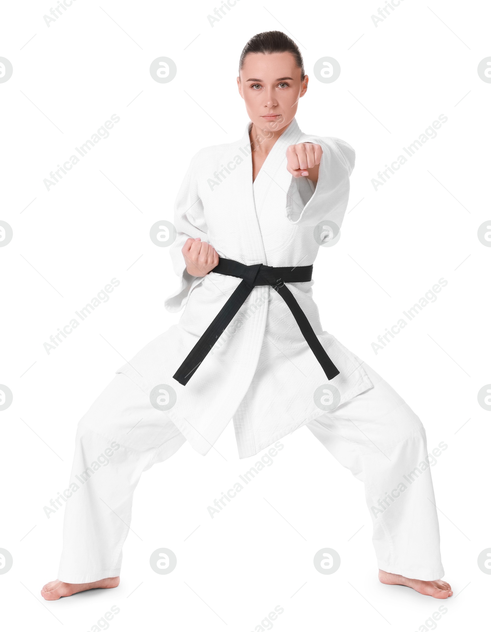 Photo of Young woman in kimono practicing karate on white background