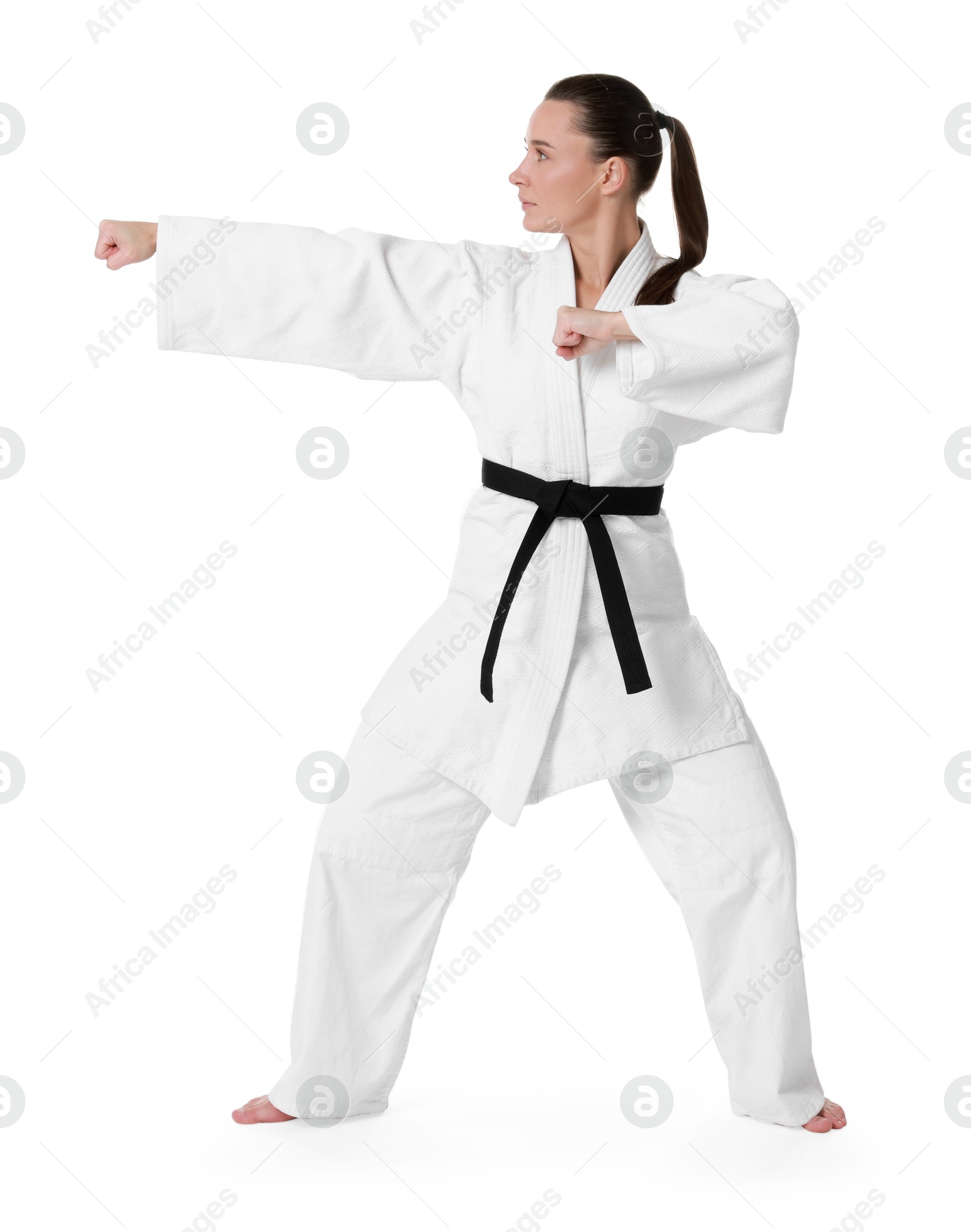 Photo of Young woman in kimono practicing karate on white background