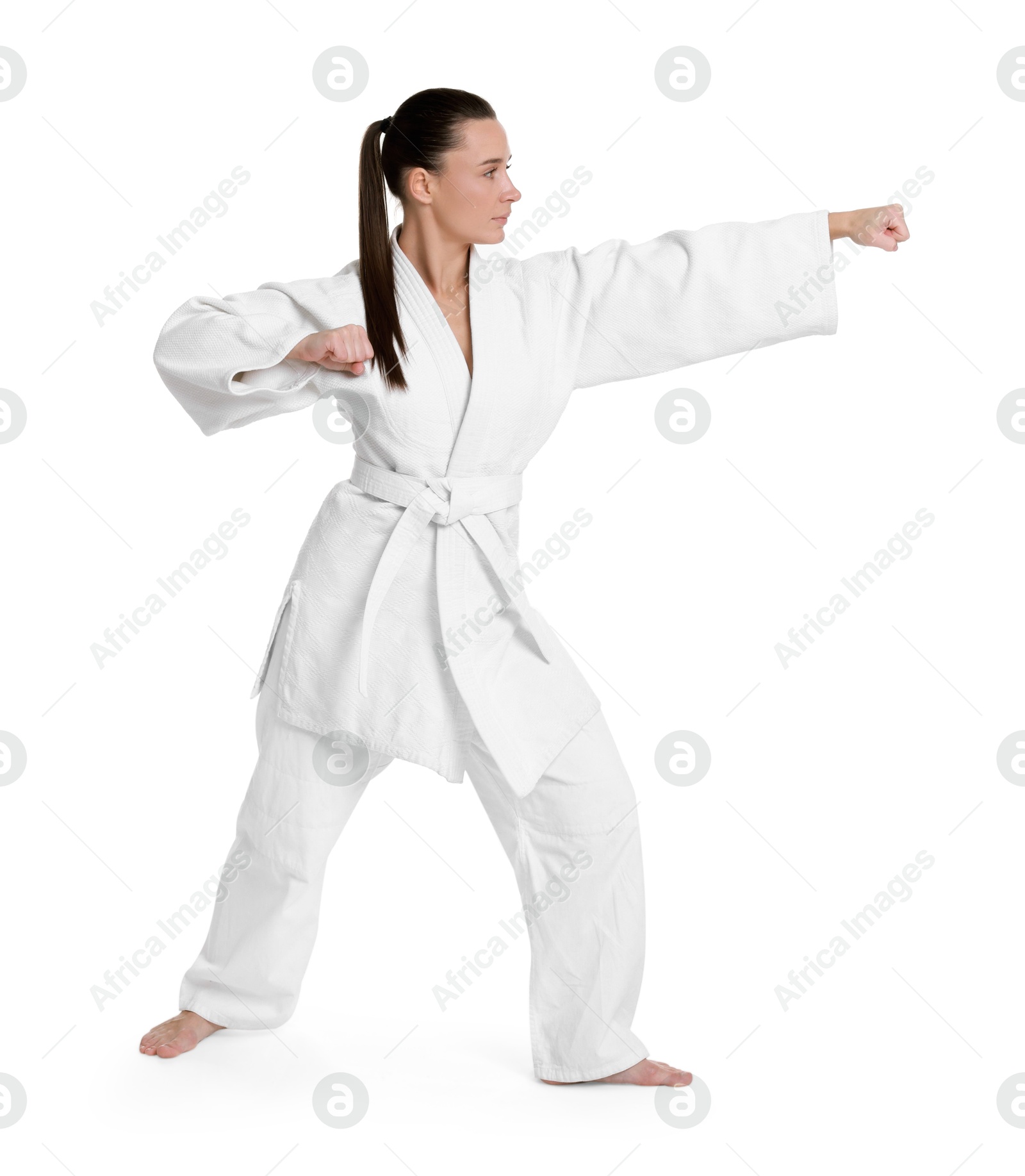 Photo of Young woman in kimono practicing karate on white background