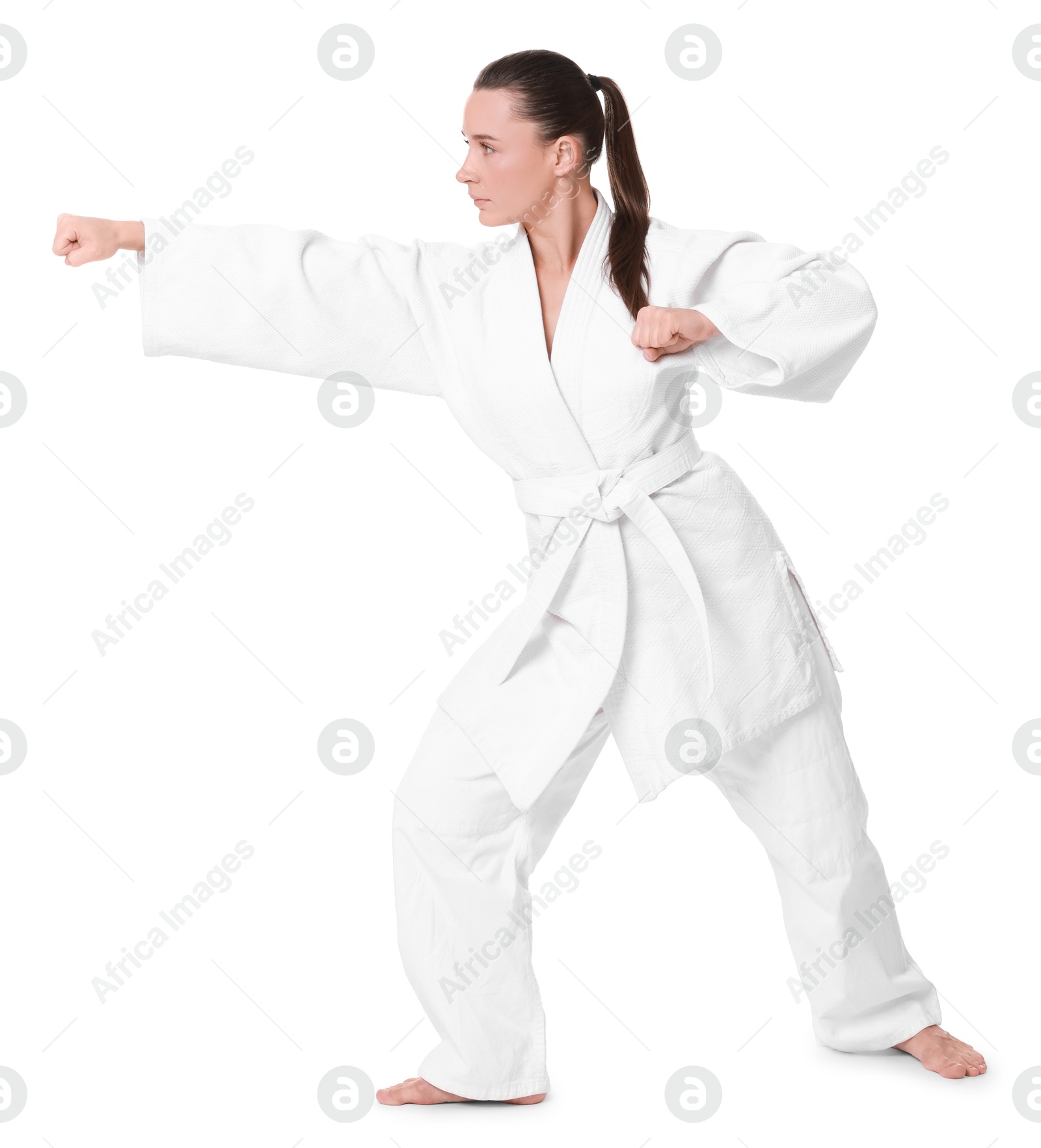 Photo of Young woman in kimono practicing karate on white background