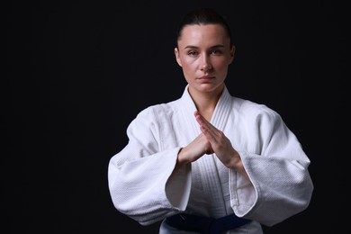 Karate fighter in kimono on black background