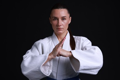 Karate fighter in kimono on black background