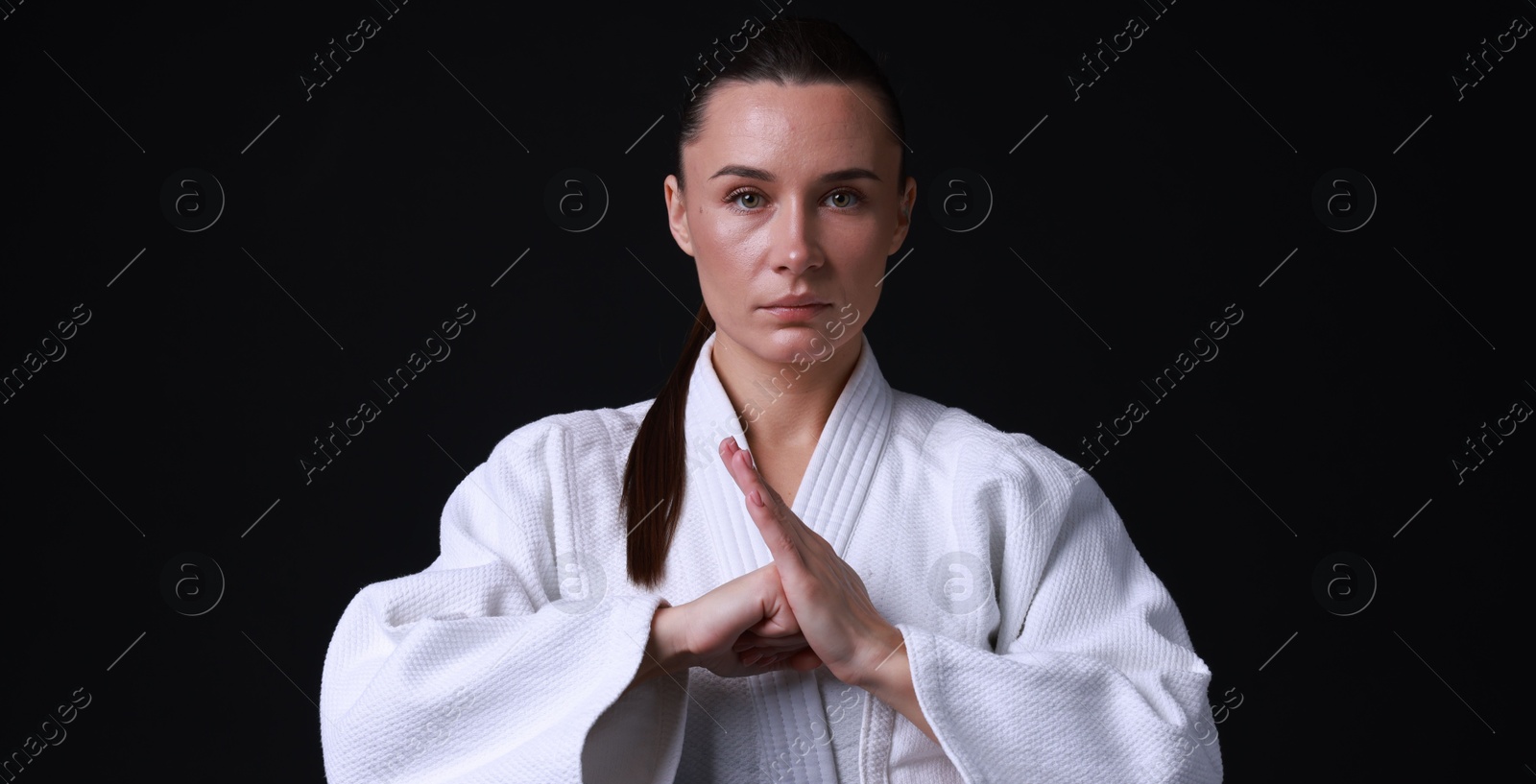 Photo of Karate fighter in kimono on black background