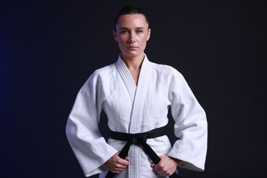 Photo of Karate fighter in kimono on dark background