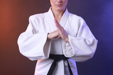 Photo of Karate fighter in kimono on color background, closeup